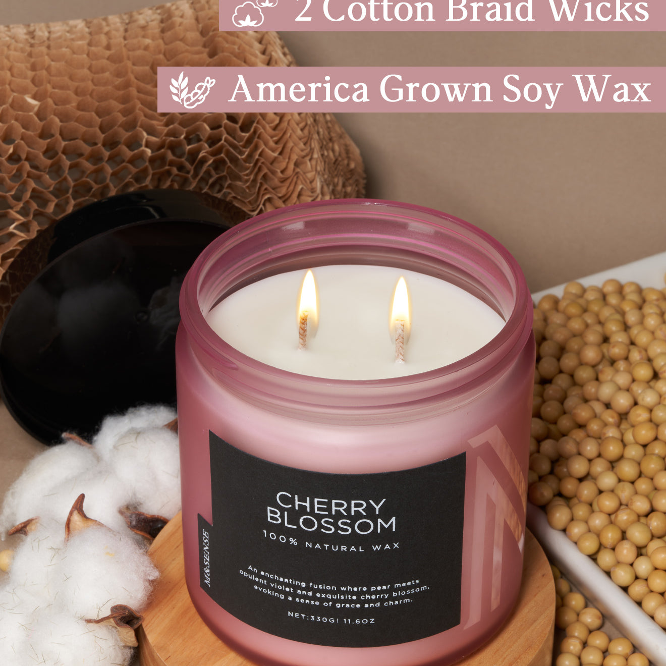 Candle with 'Cherry Blossom' label on a wooden surface with cotton and soybeans, featuring text about wicks and wax.