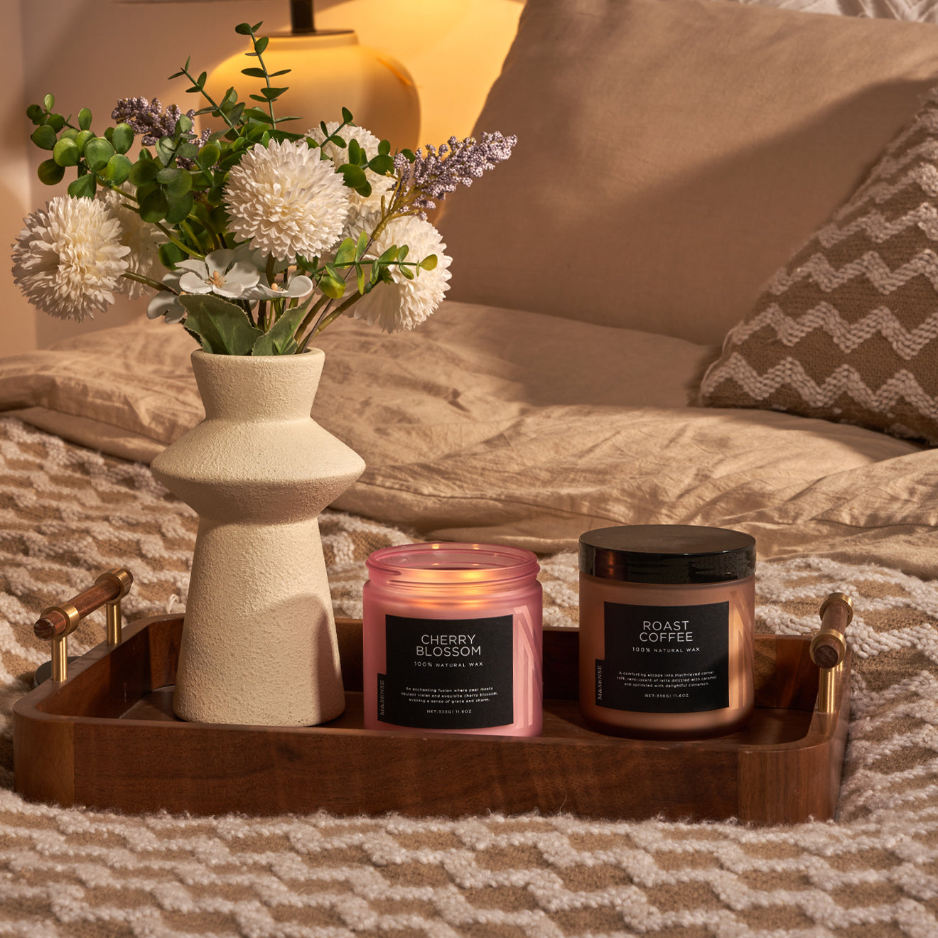 Bedroom decor with cherry blossom and roast coffee scented candles on wooden tray beside vase
