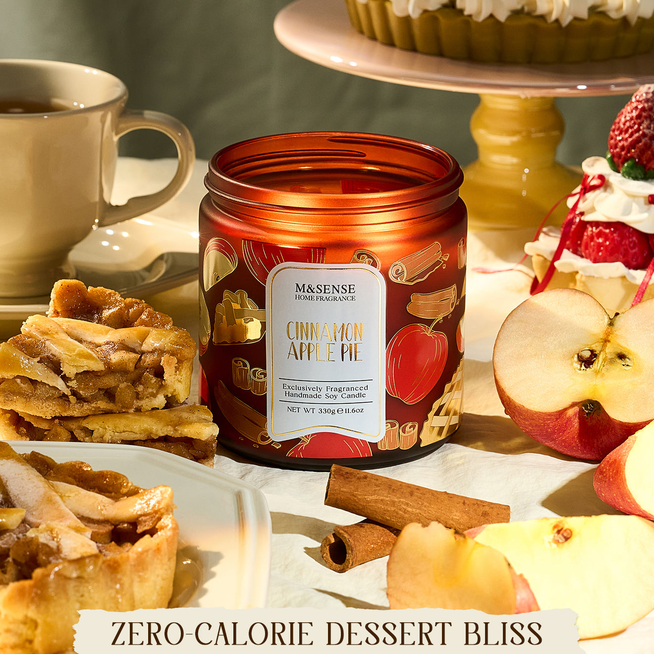 Candle with apple pie design surrounded by apple slices, pies, and a cup on a neutral background