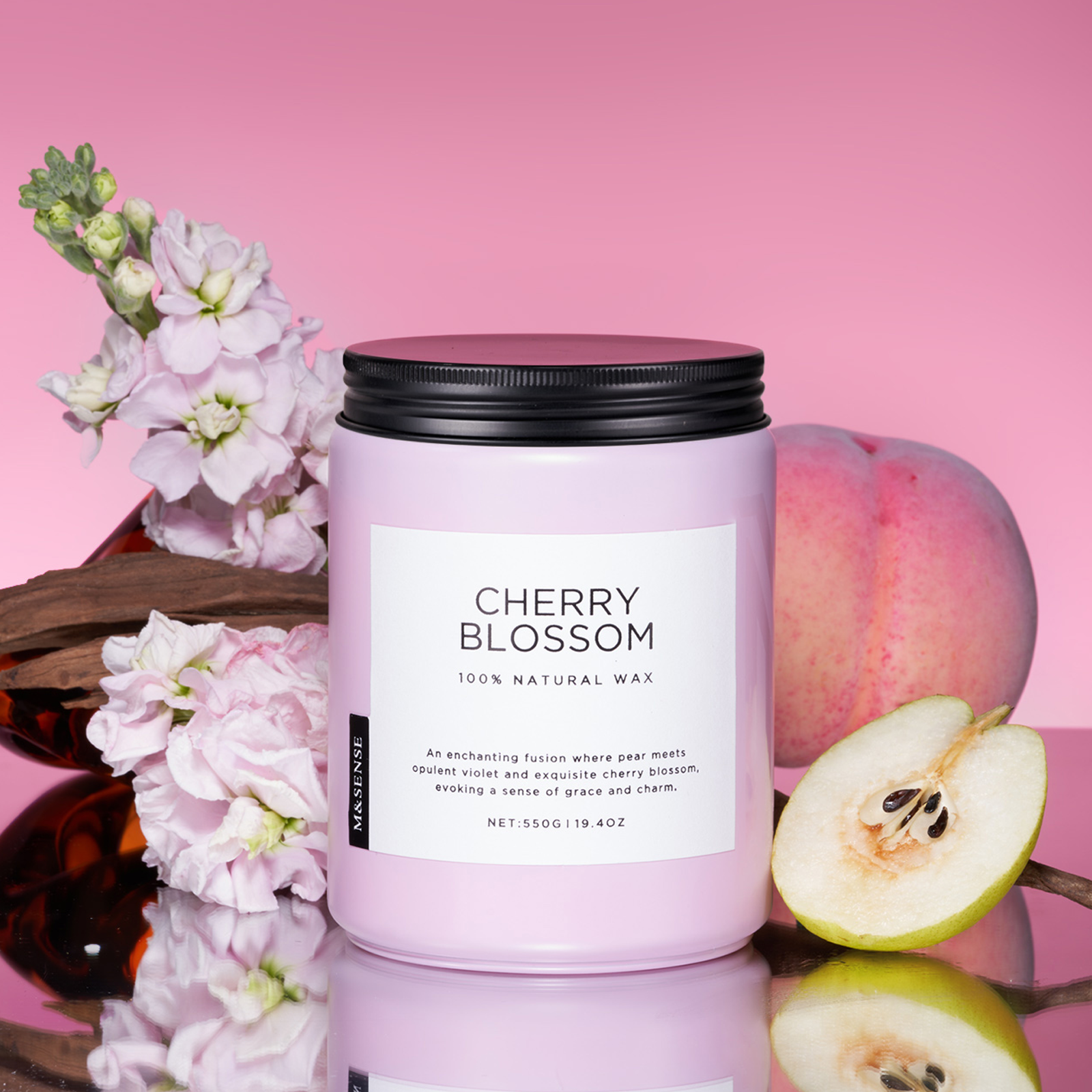 Candle labeled 'Cherry Blossom' with flowers and fruit on a pink background