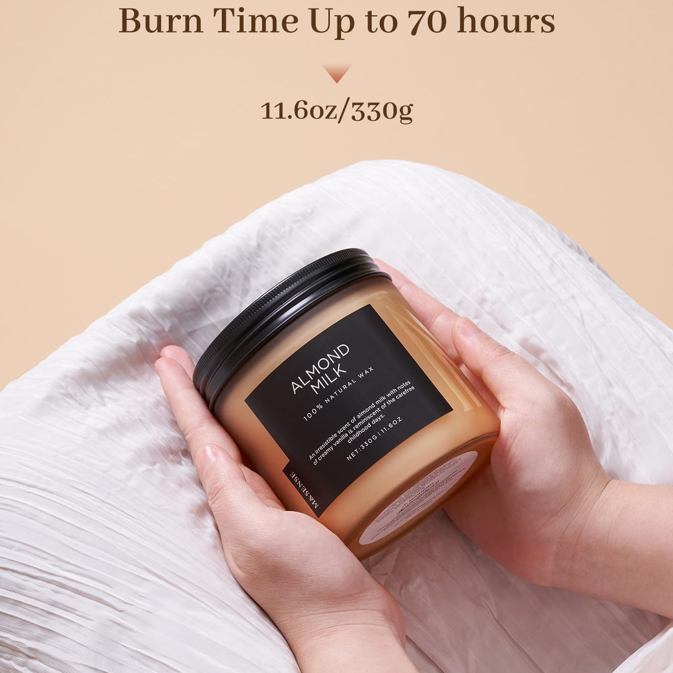 Candle labeled 'Almond Milk' held by a hand with text indicating burn time and weight.