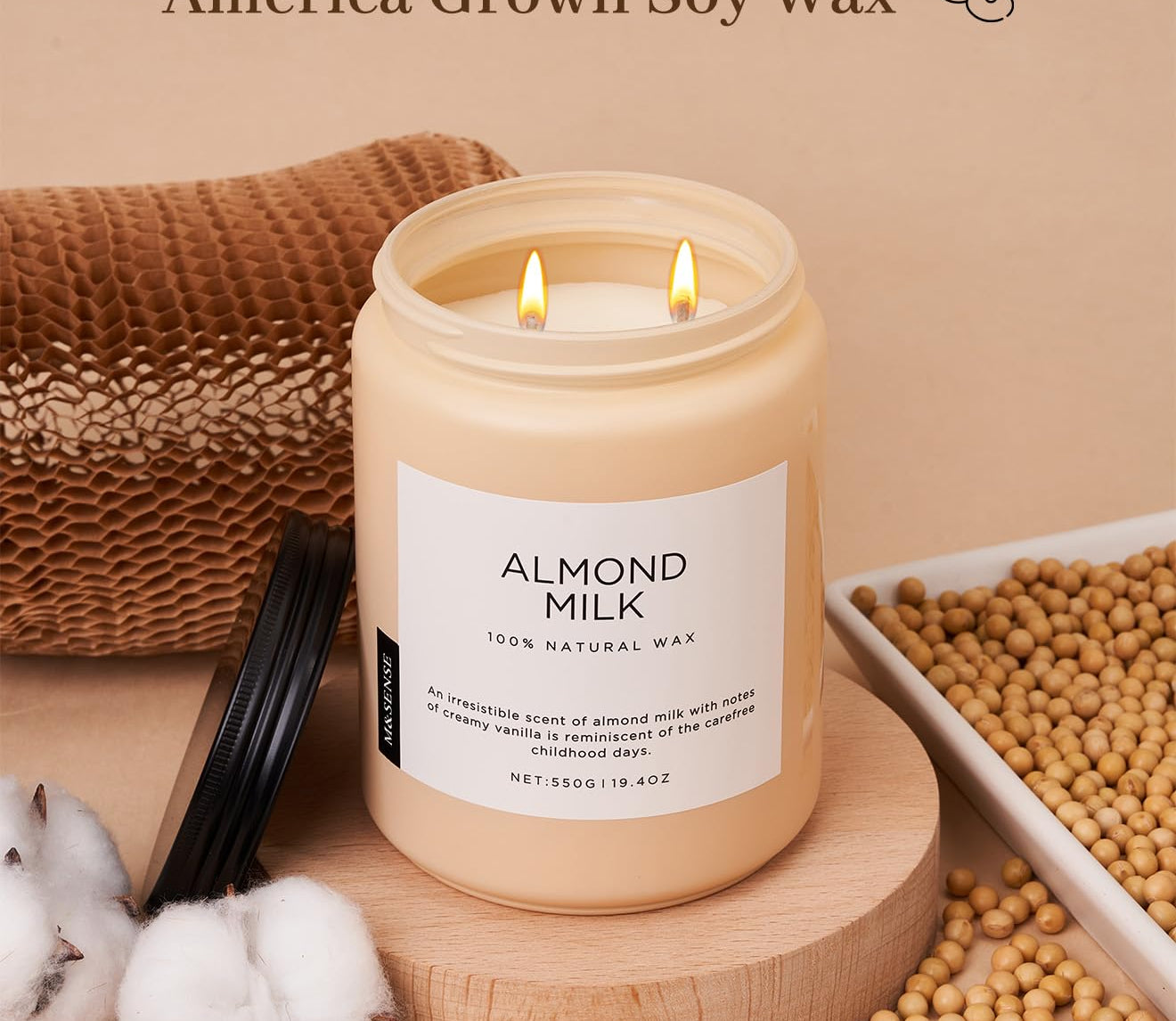 Candle labeled 'Almond Milk' with cotton braid wicks and soy wax on a beige background