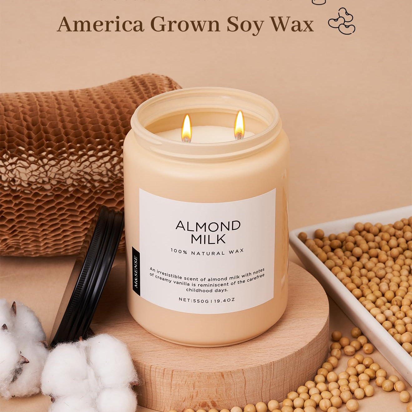 Candle labeled 'Almond Milk' with cotton braid wicks and soy wax on a beige background