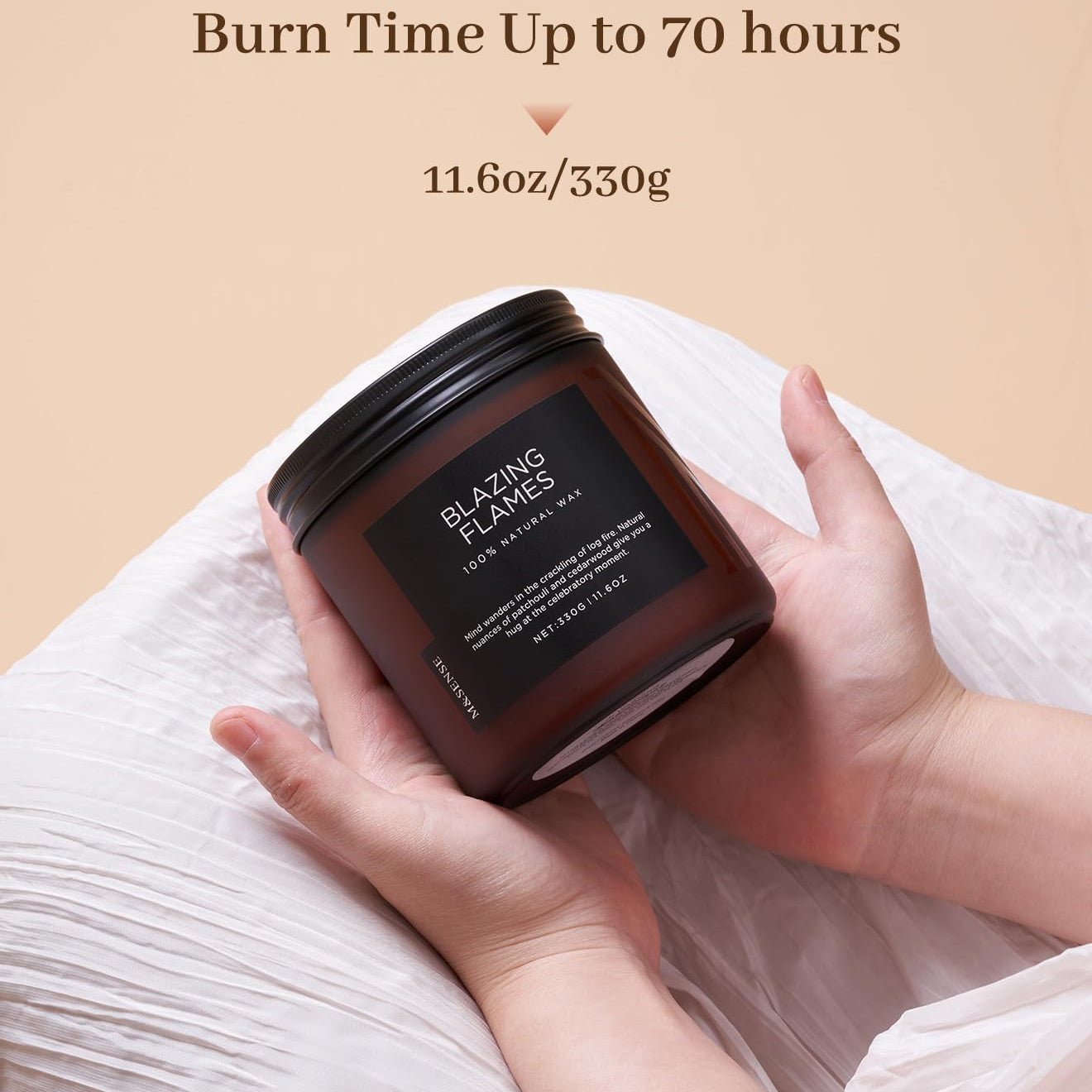 Hand holding a candle labeled 'Blazing Flames' with text about burn time and weight on a beige background.