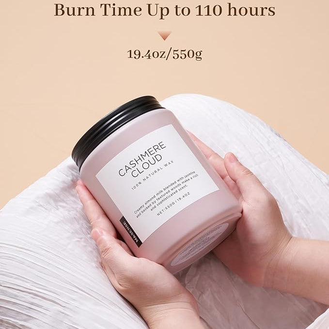 Candle labeled 'Cashmere Cloud' held by a hand with a beige background