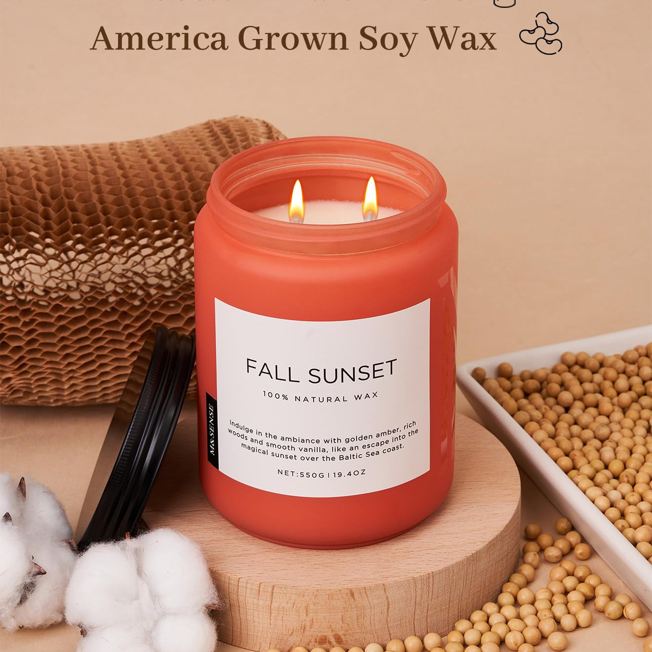 Red candle labeled 'Fall Sunset' with cotton braid wicks and soy wax on a beige background