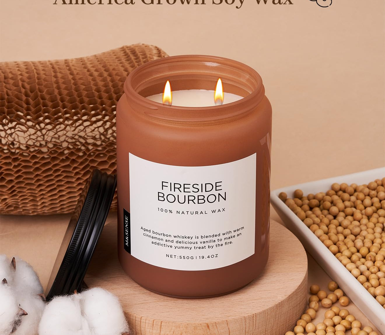 Candle labeled 'Fireside Bourbon' with soy wax and cotton braid wicks on a wooden surface.