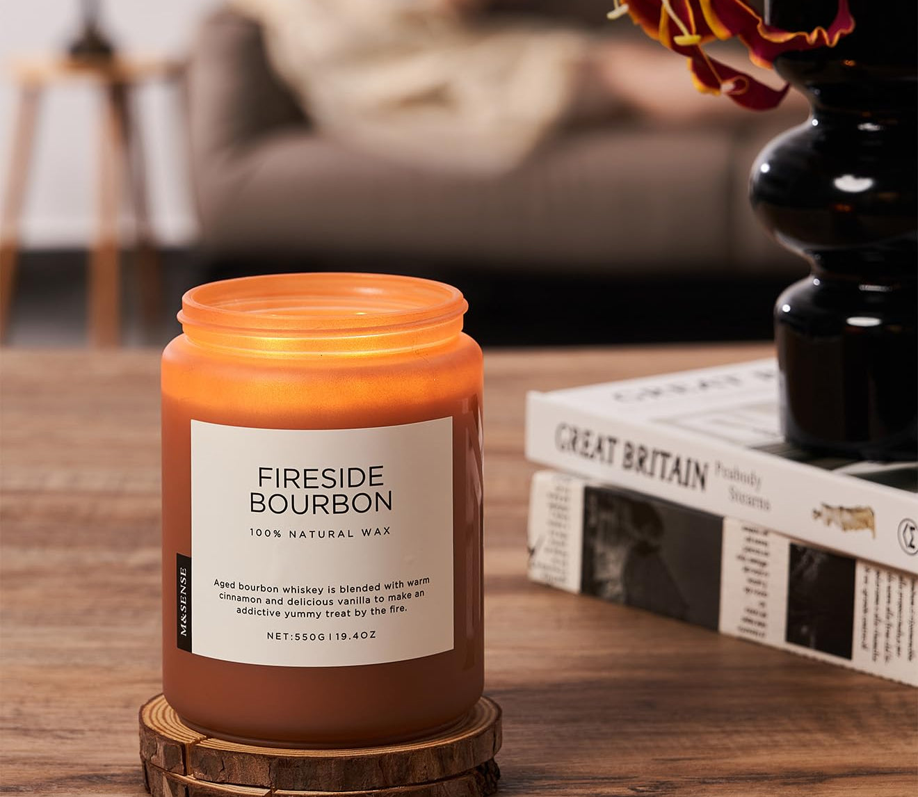 Fireside Bourbon candle on a wooden coaster with a cozy living room background