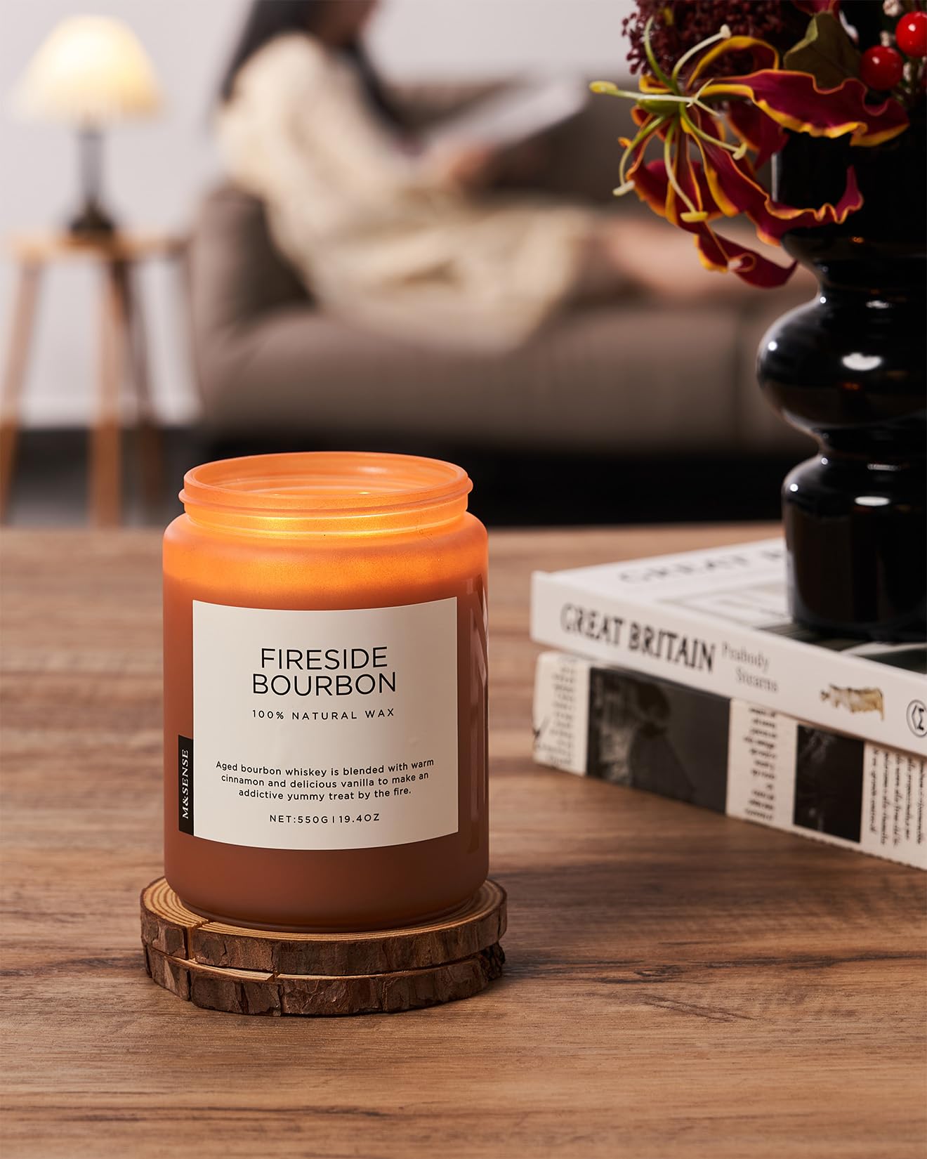 Fireside Bourbon candle on a wooden coaster with a cozy living room background