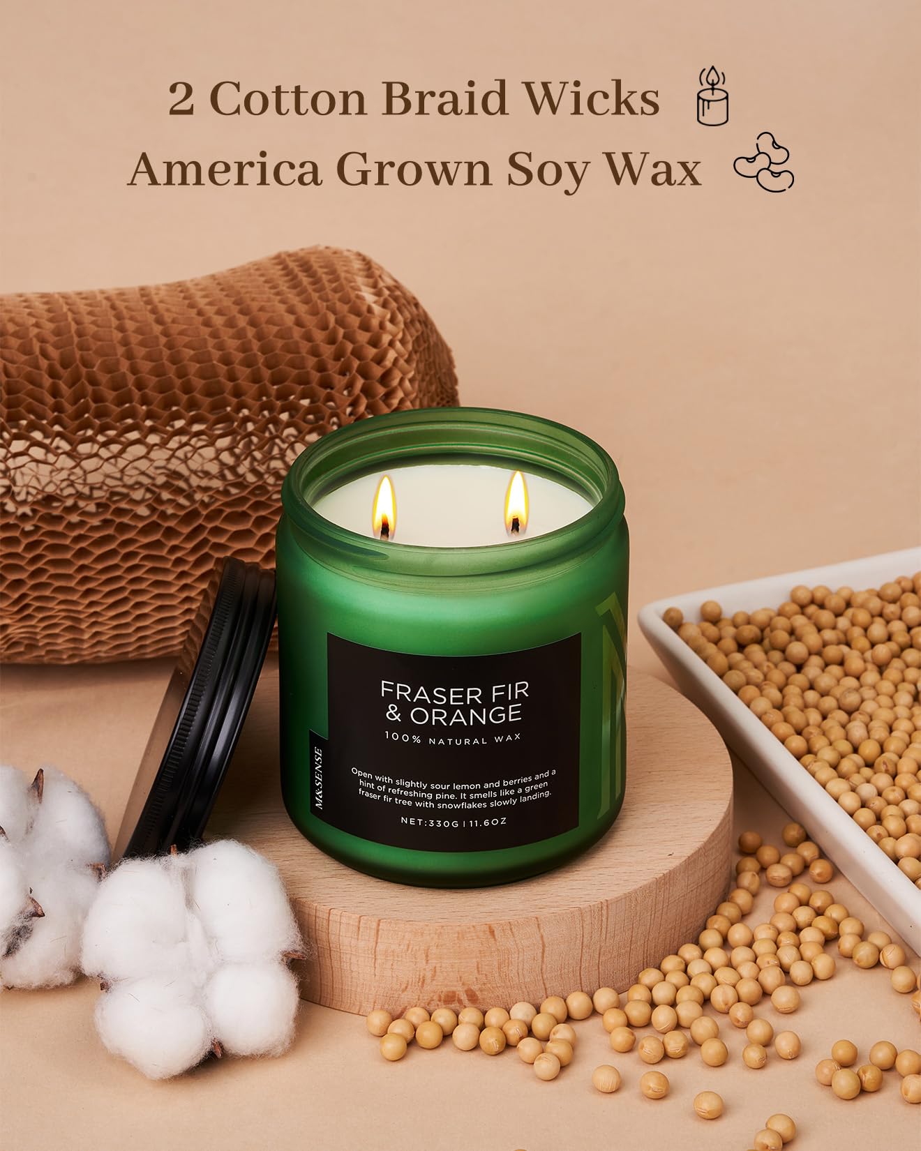 Green candle labeled 'Fraser Fir & Orange' with cotton, soybeans, and a woven basket on a beige background.