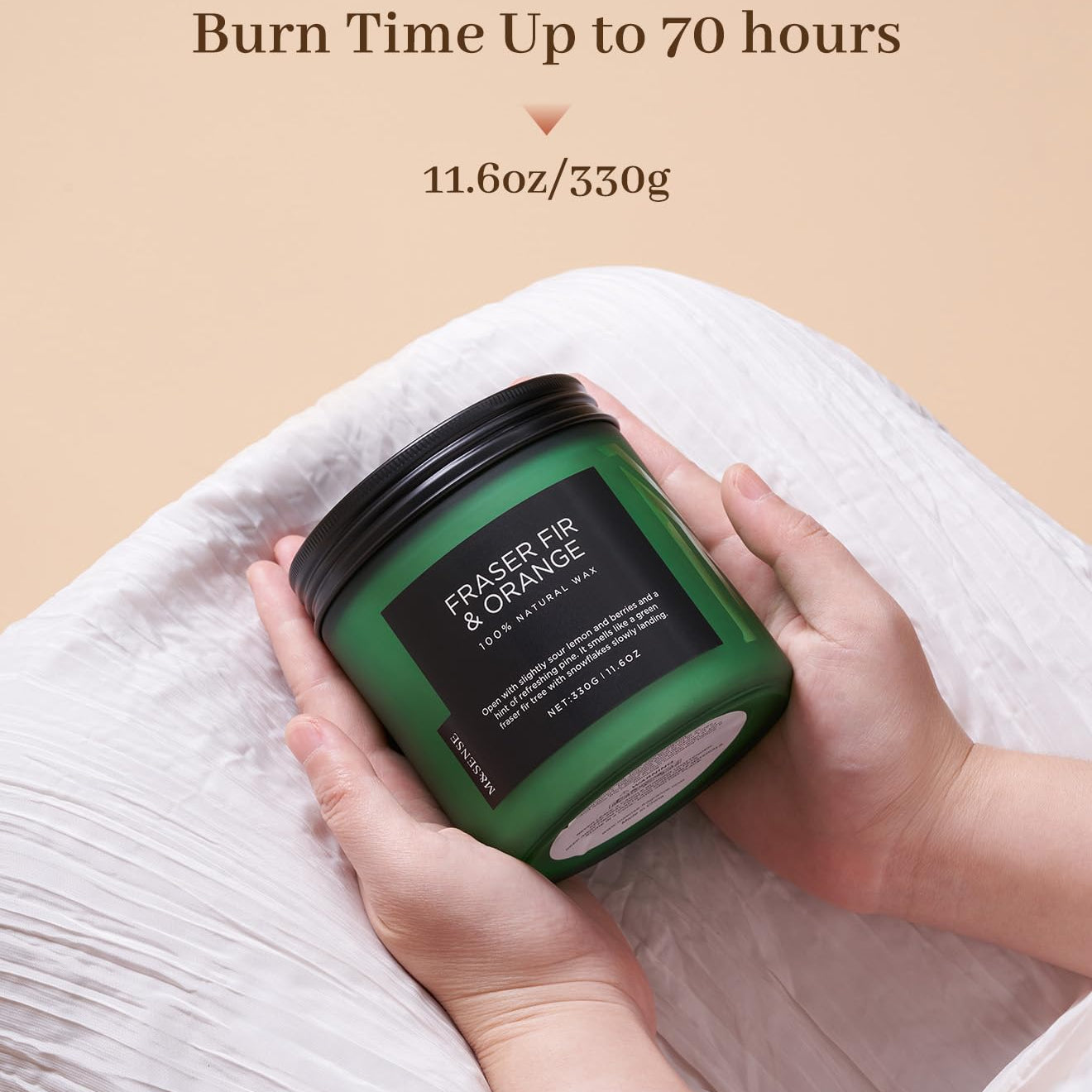 Green candle with black lid held by hands on a beige background, featuring text about burn time and weight.