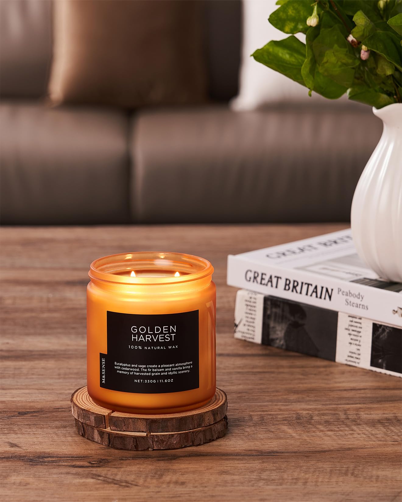 Candle labeled 'Golden Harvest' on a wooden coaster with a blurred background
