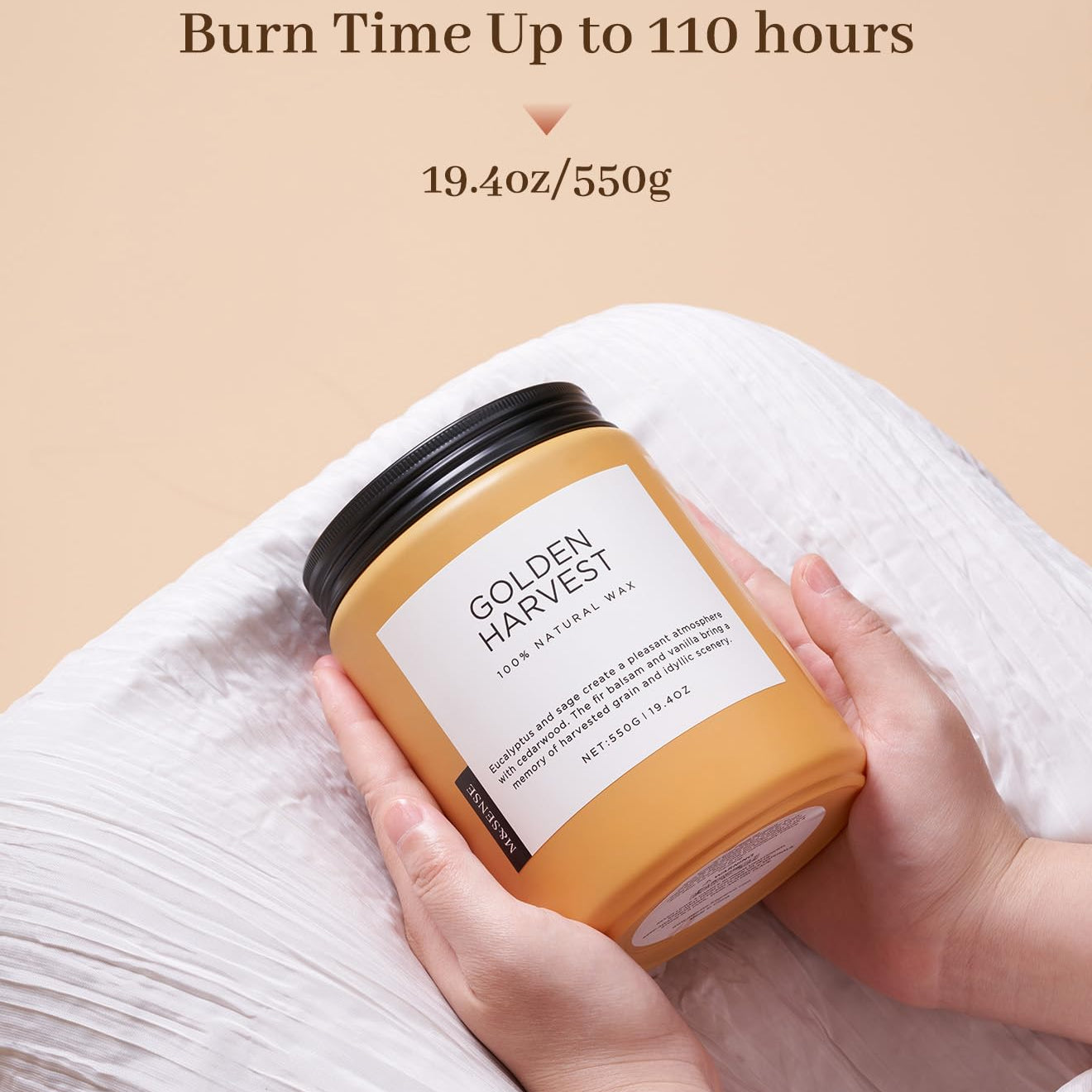 Hand holding a 'Golden Harvest' candle with product details on a beige background