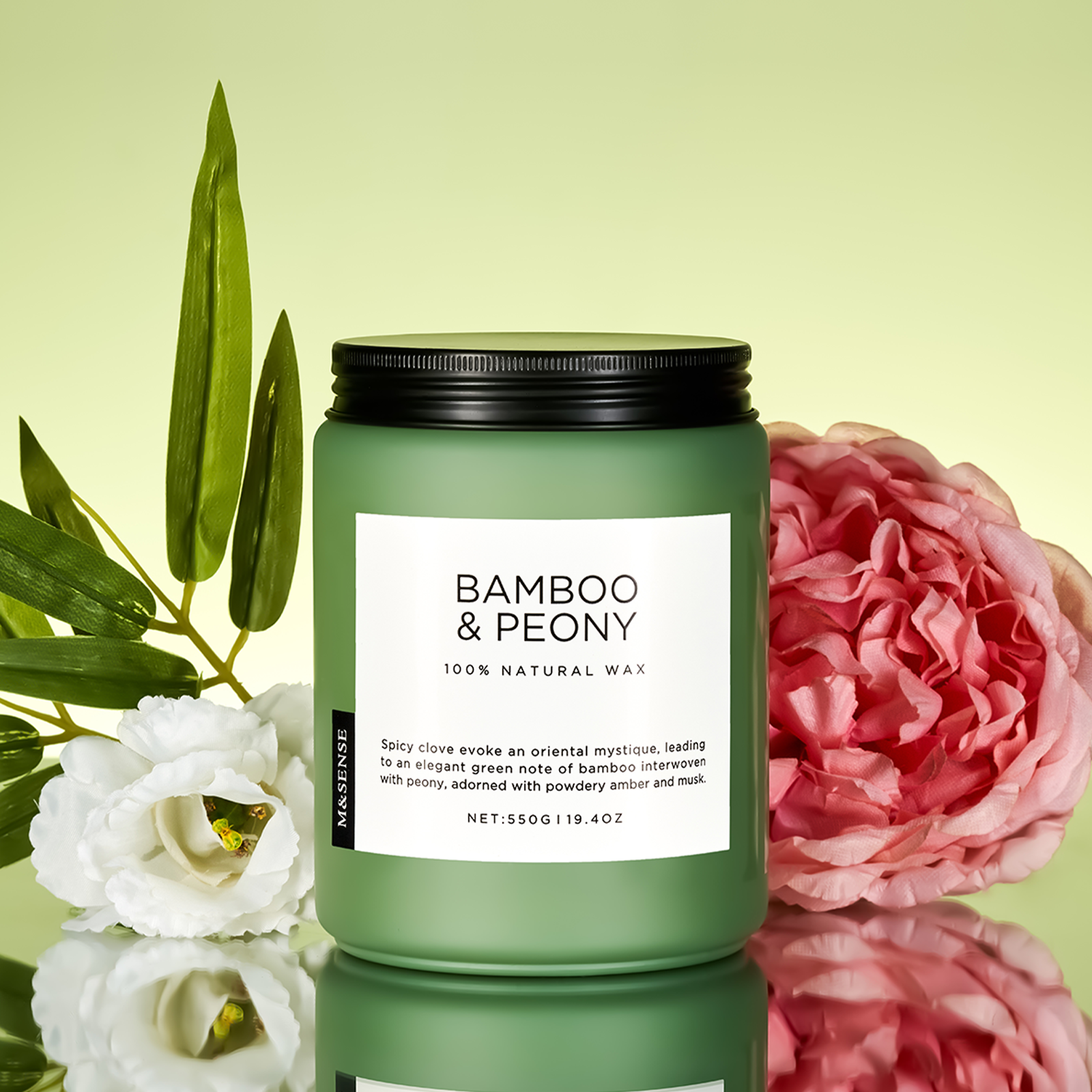 Green candle labeled 'Bamboo & Peony' with floral elements on a reflective surface.