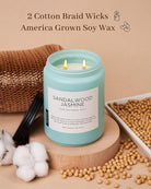 Candle with sandalwood jasmine scent on a wooden stand with cotton and soybeans, labeled '2 Cotton Braid Wicks America Grown Soy Wax'.