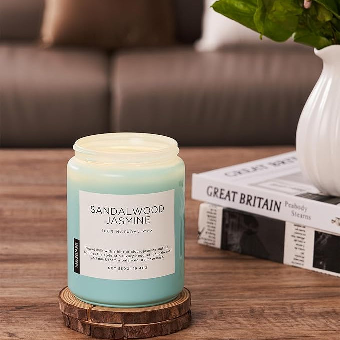 Sandalwood Jasmine candle on a wooden coaster with a blurred background