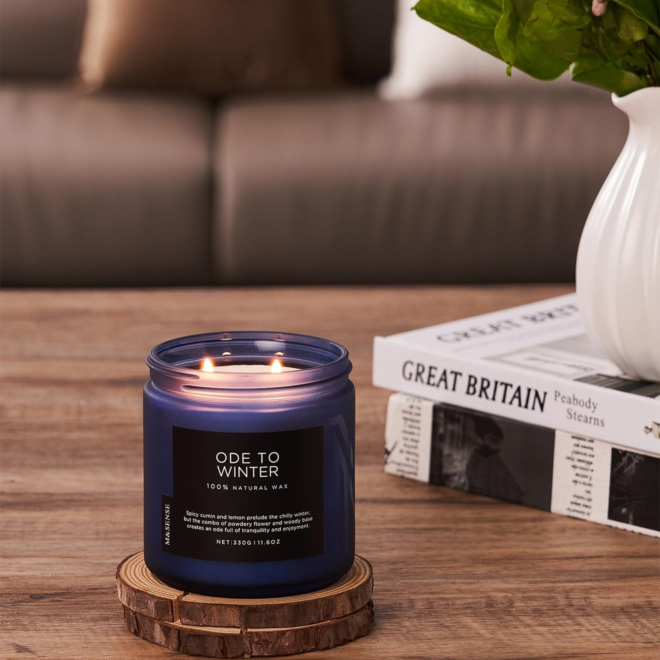 Candle labeled 'Ode to Winter' on a wooden coaster with a blurred background