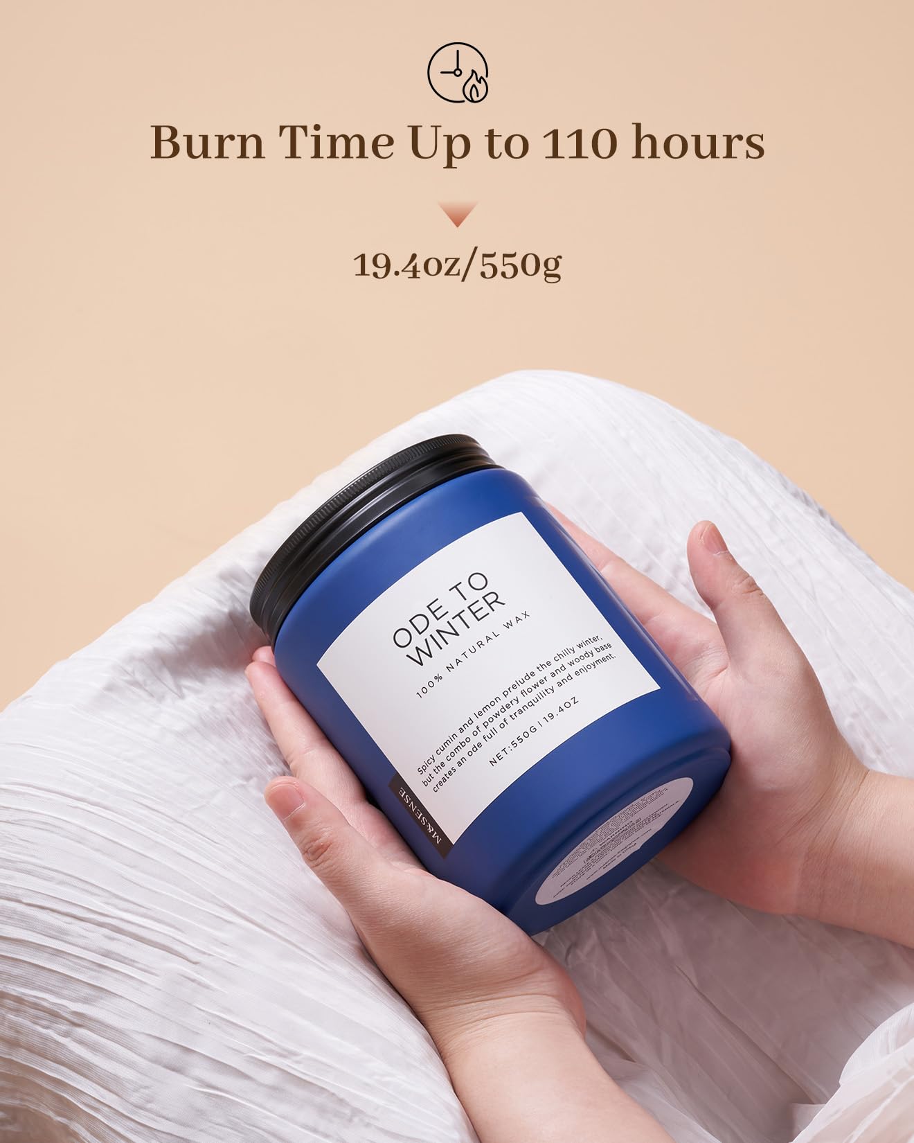 Blue candle labeled 'Ode to Winter' held by a hand with beige background