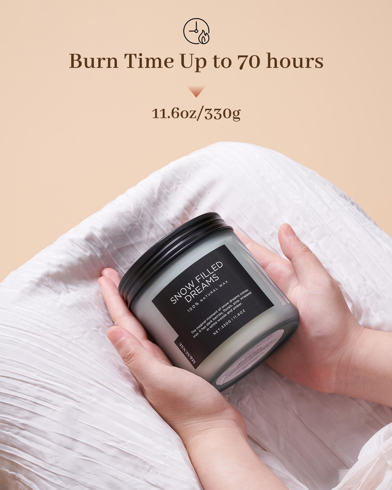 Candle labeled 'Snow Filled Dreams' held by a hand with beige background and text about burn time.