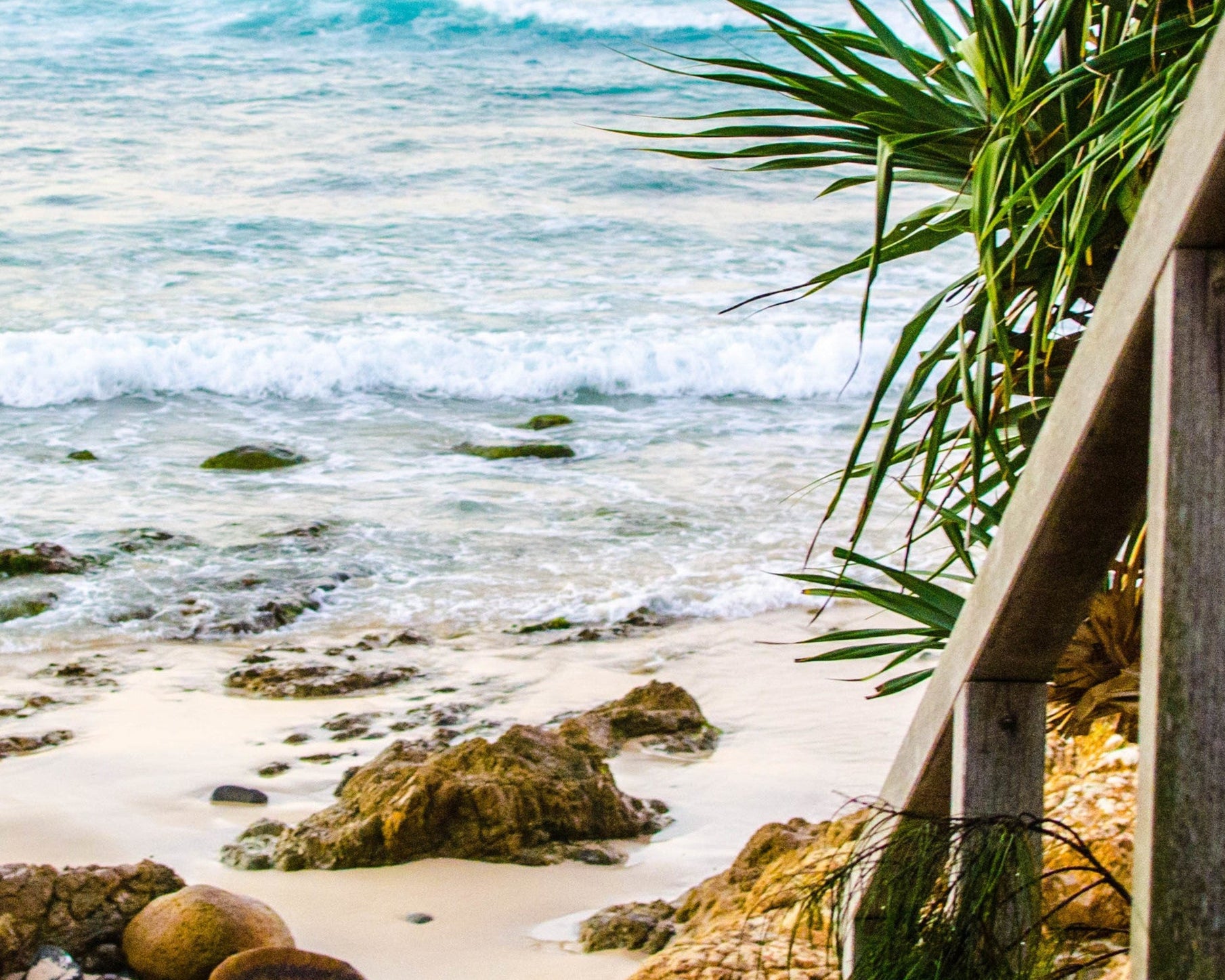 Wooden steps leading to a beach with ocean view
