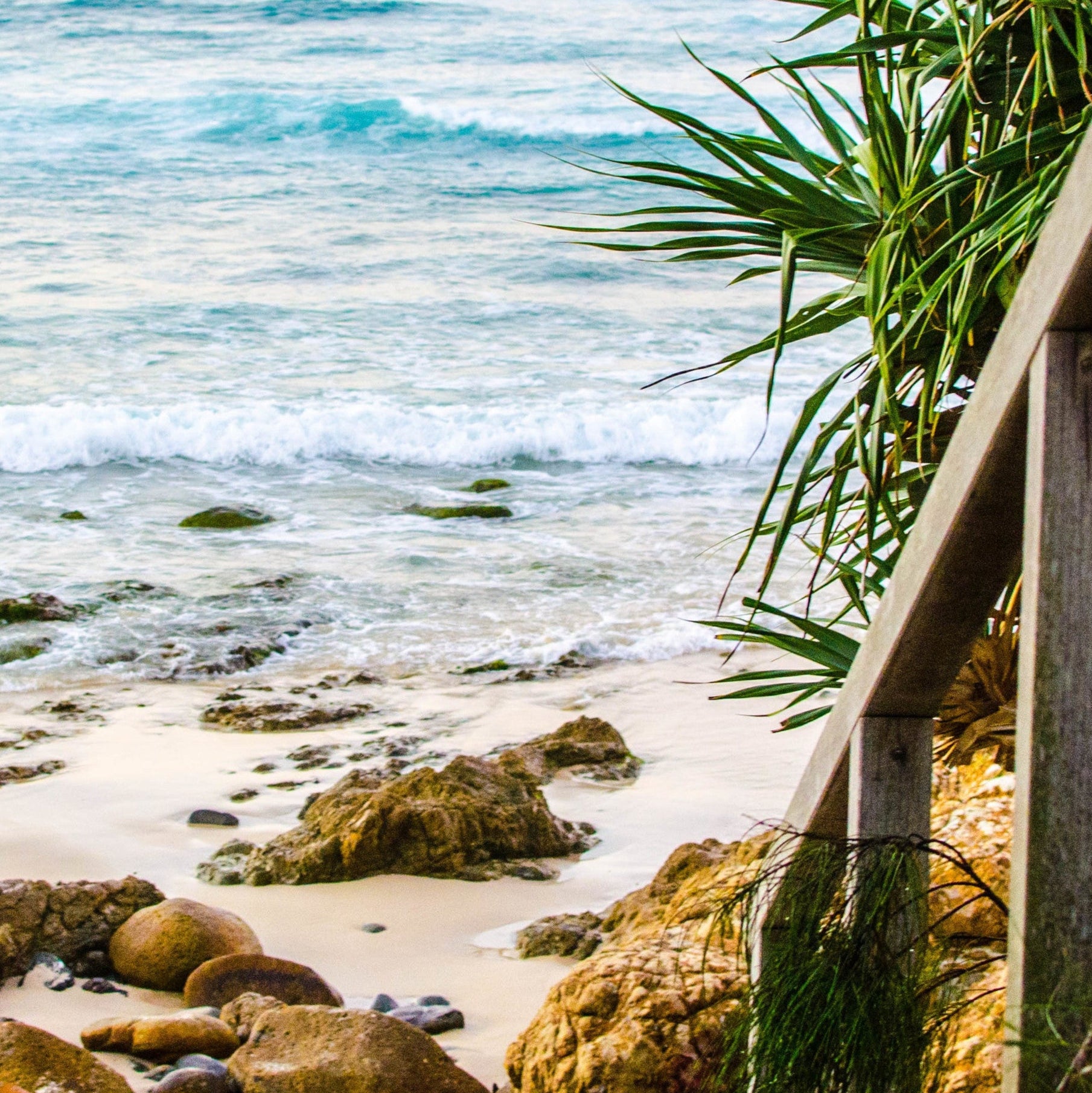 Wooden steps leading to a beach with ocean view