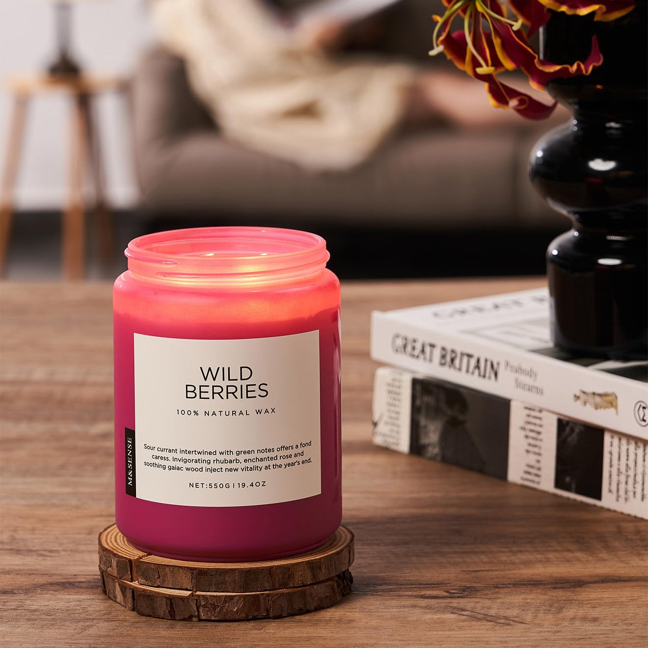 Candle labeled 'Wild Berries' on a wooden surface with a blurred background