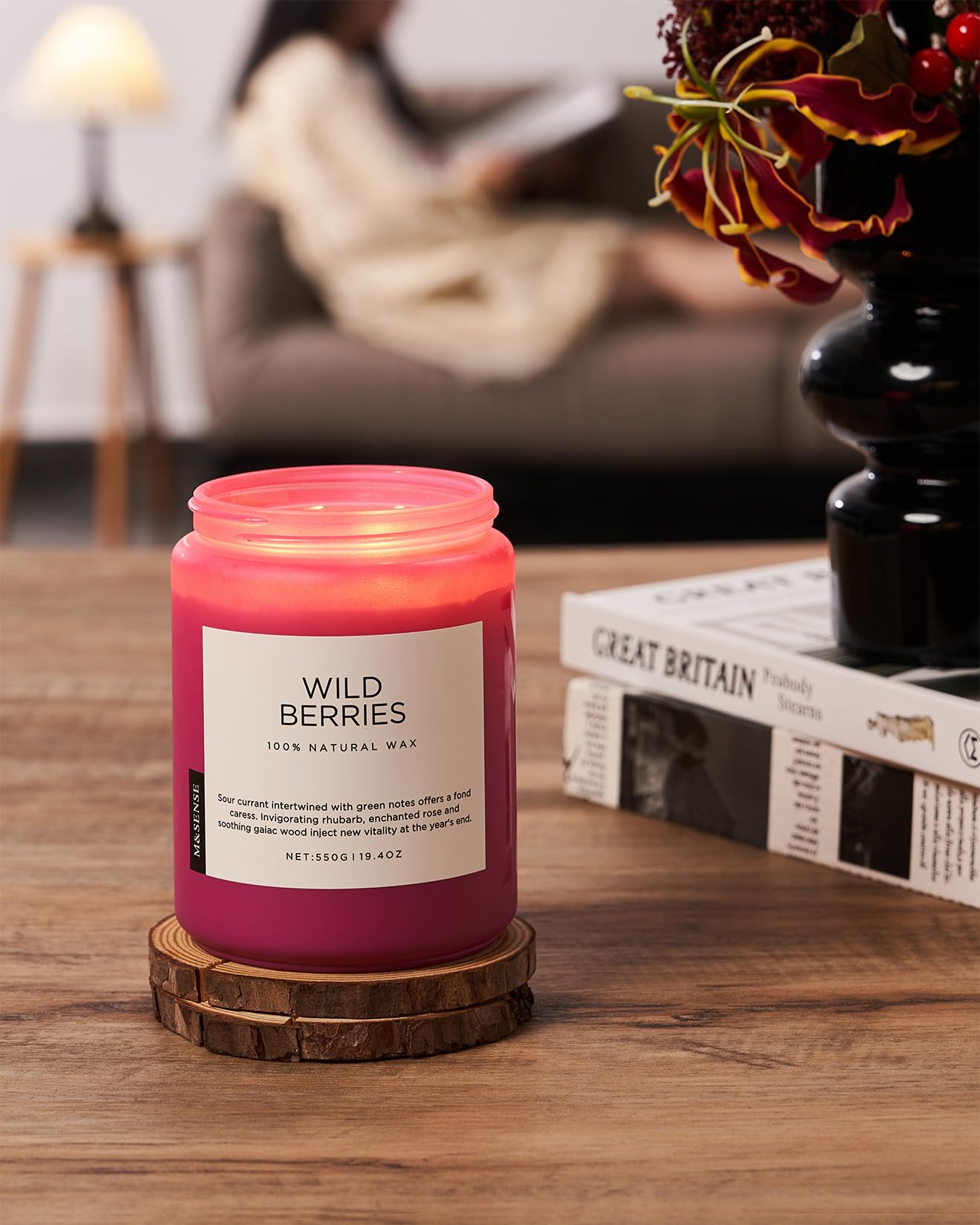 Candle labeled 'Wild Berries' on a wooden surface with a blurred background