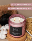 Candle with 'Cherry Blossom' label on a wooden surface with cotton and soybeans, featuring text about wicks and wax.