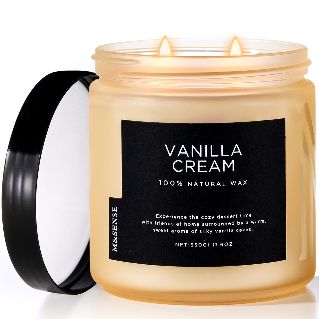 A beige candle with a black lid and label that reads 'VANILLA CREAM 100% NATURAL WAX'. The candle is placed on a white surface.
