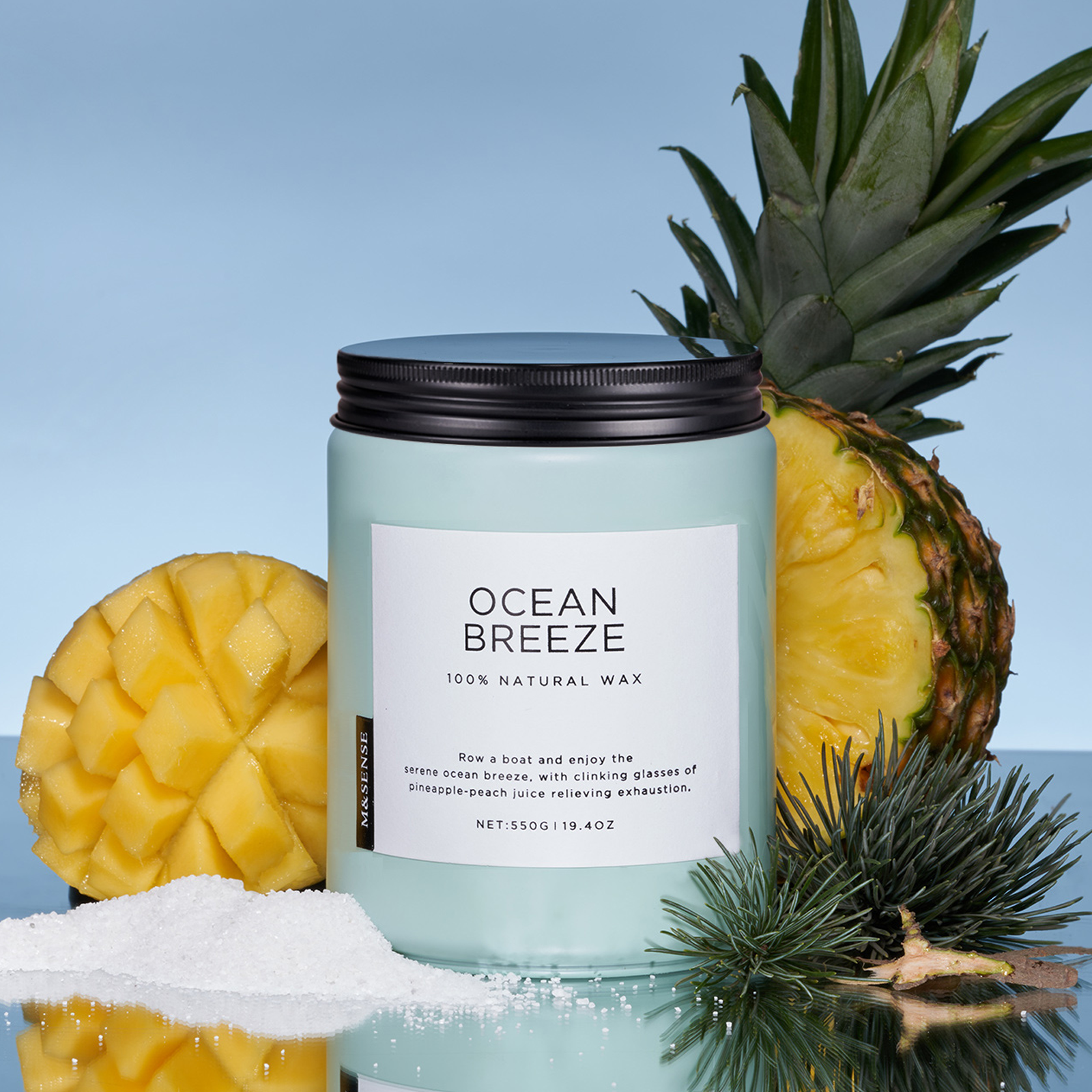 Candle labeled 'Ocean Breeze' with a pineapple and salt on a blue background