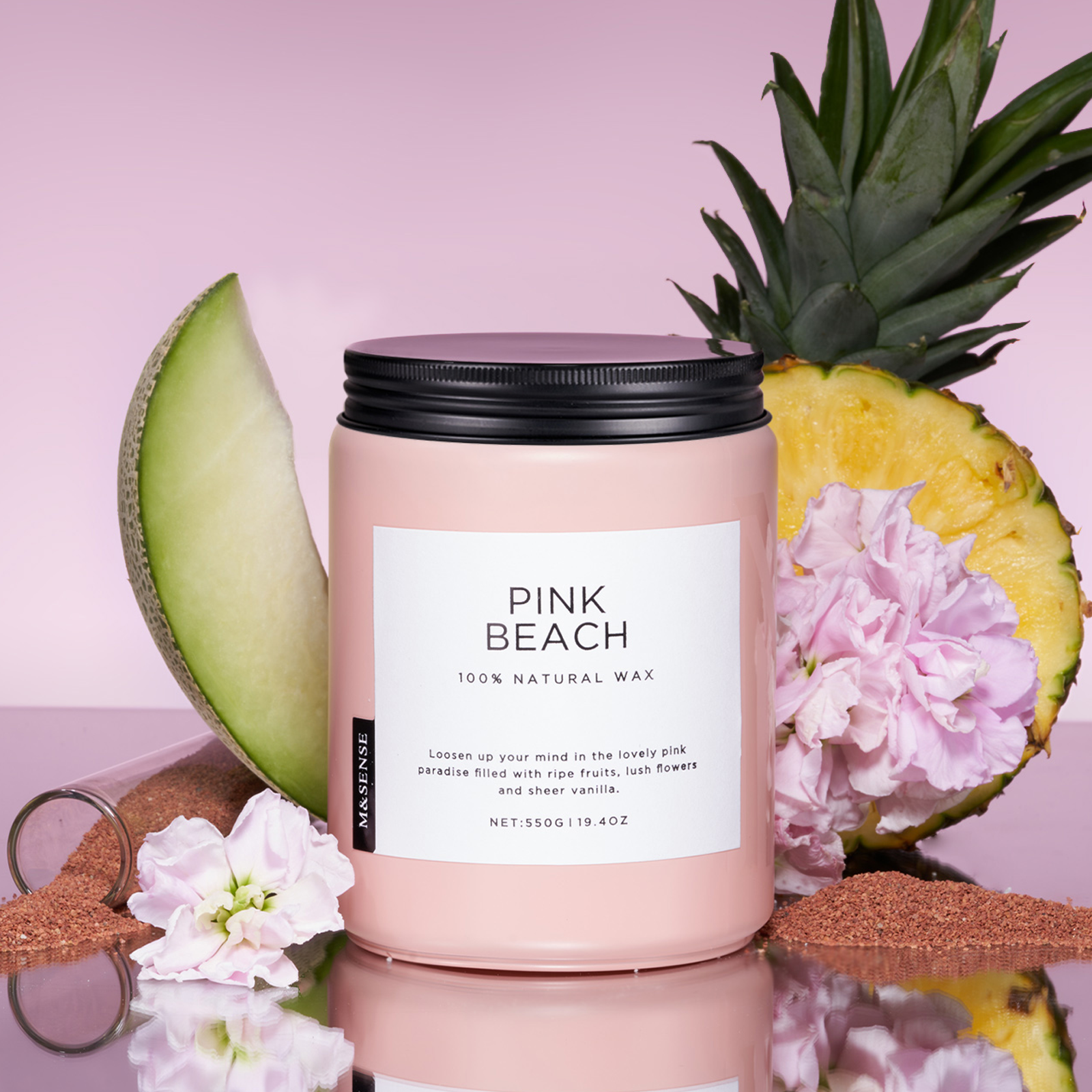 Pink candle labeled 'Pink Beach' with a pineapple, cantaloupe, and flowers on a pink background