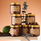 Collection of candles with labels on a wooden surface and beige background