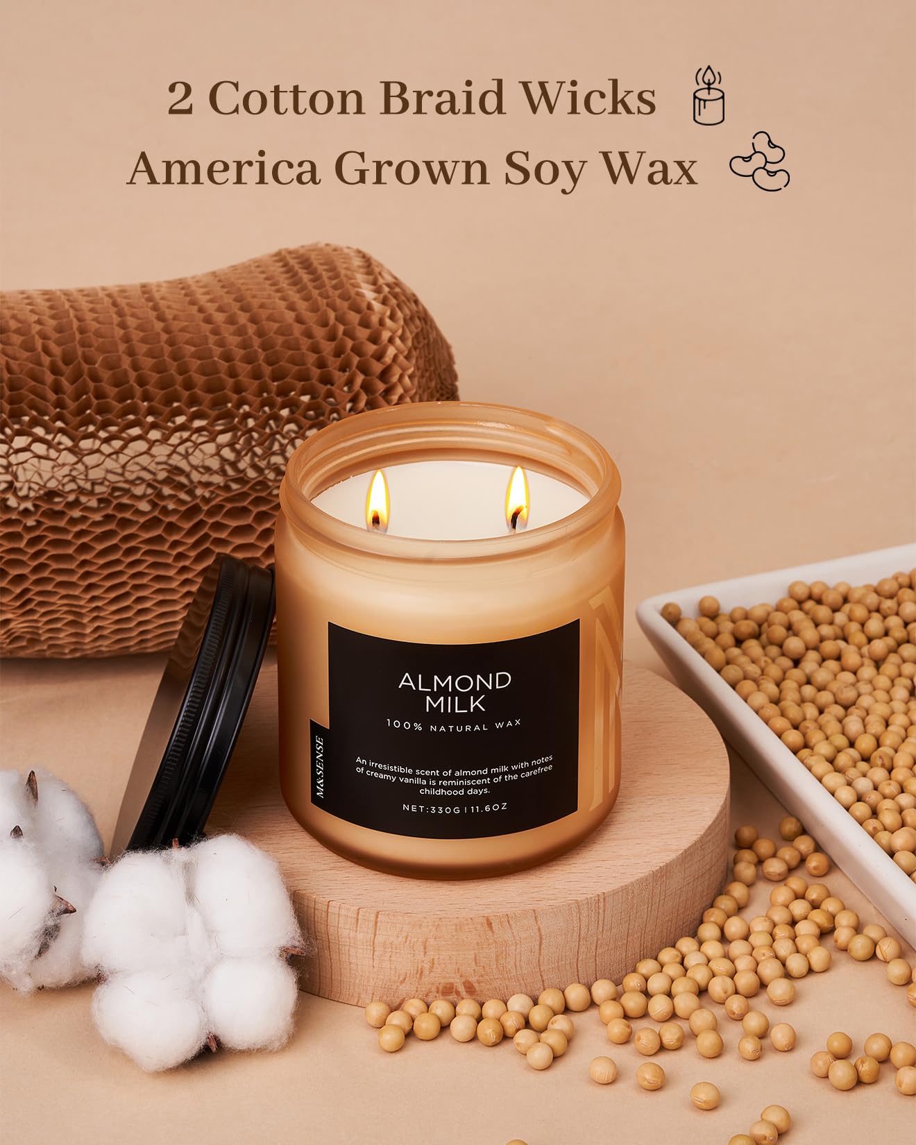 Candle with 'Almond Milk' label, surrounded by soybeans and cotton, on a beige background.