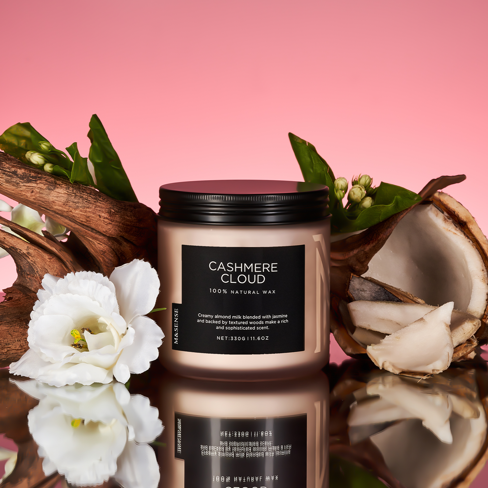 Candle labeled 'Cashmere Cloud' with flowers and a coconut on a pink background