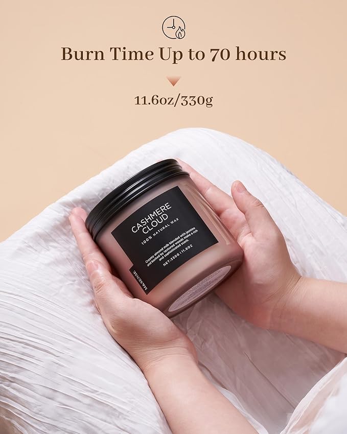 Candle with a label held by hands against a beige background, featuring text about burn time and weight.