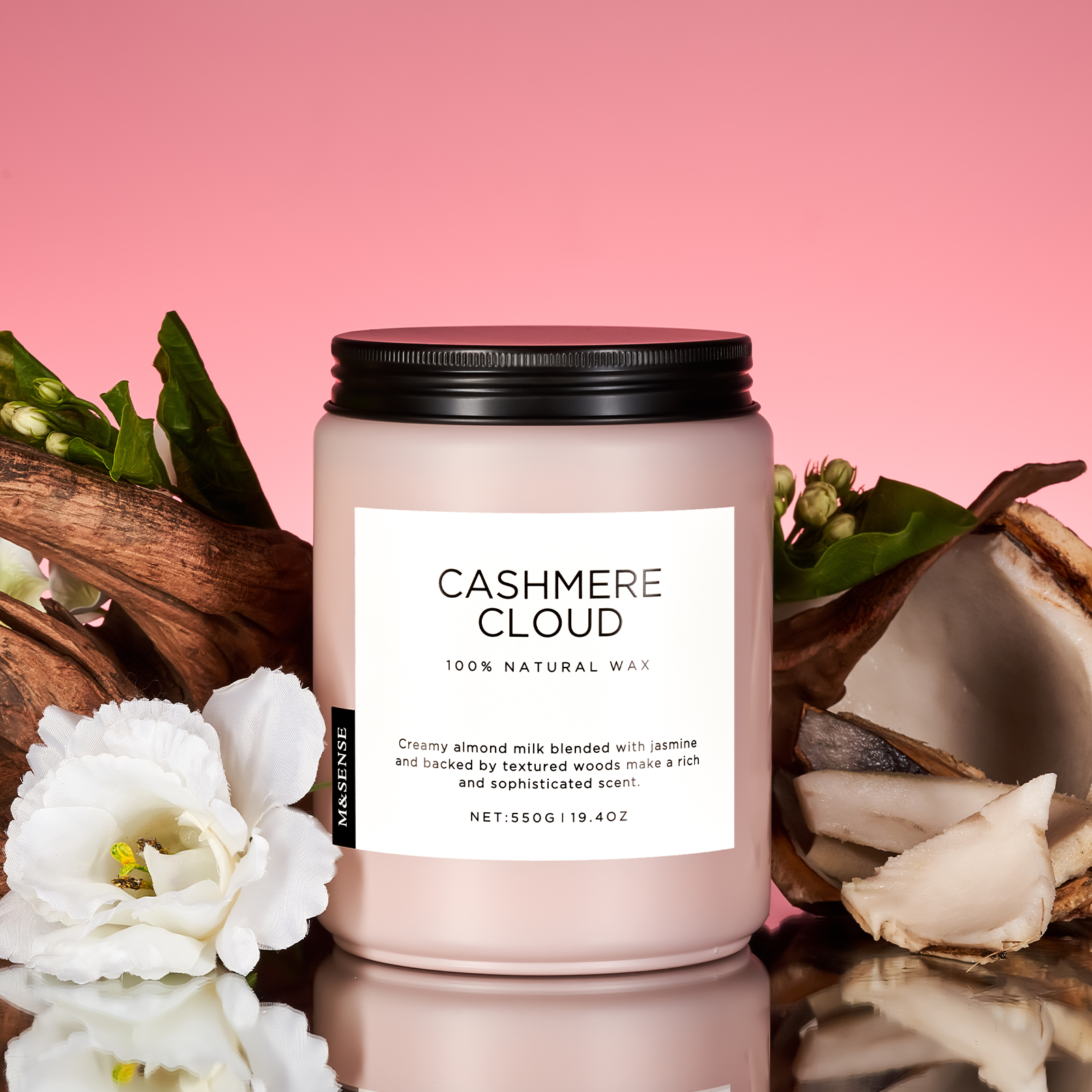 Candle labeled 'Cashmere Cloud' with natural elements on a pink background