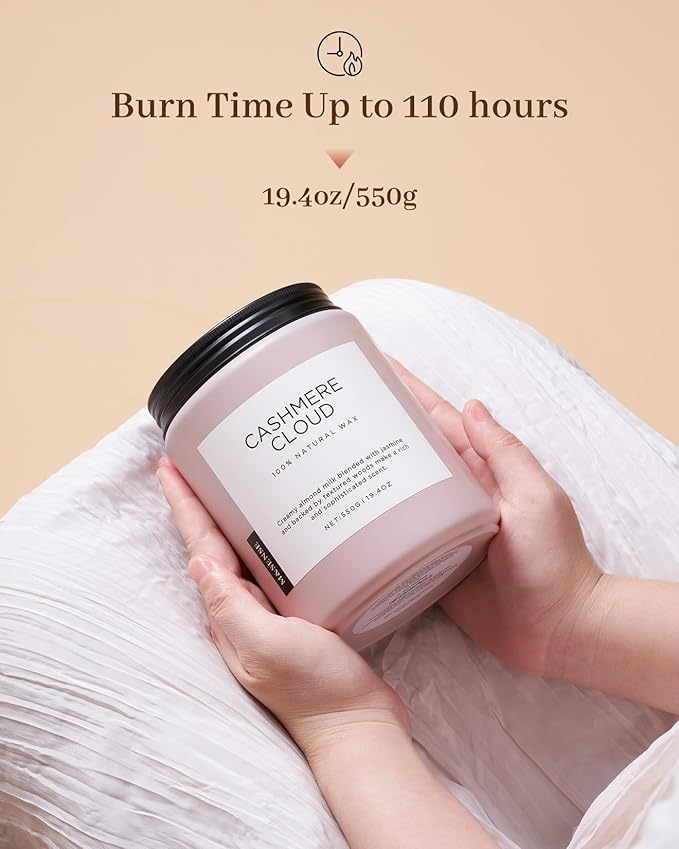 Candle labeled 'Cashmere Cloud' held by a hand with a beige background