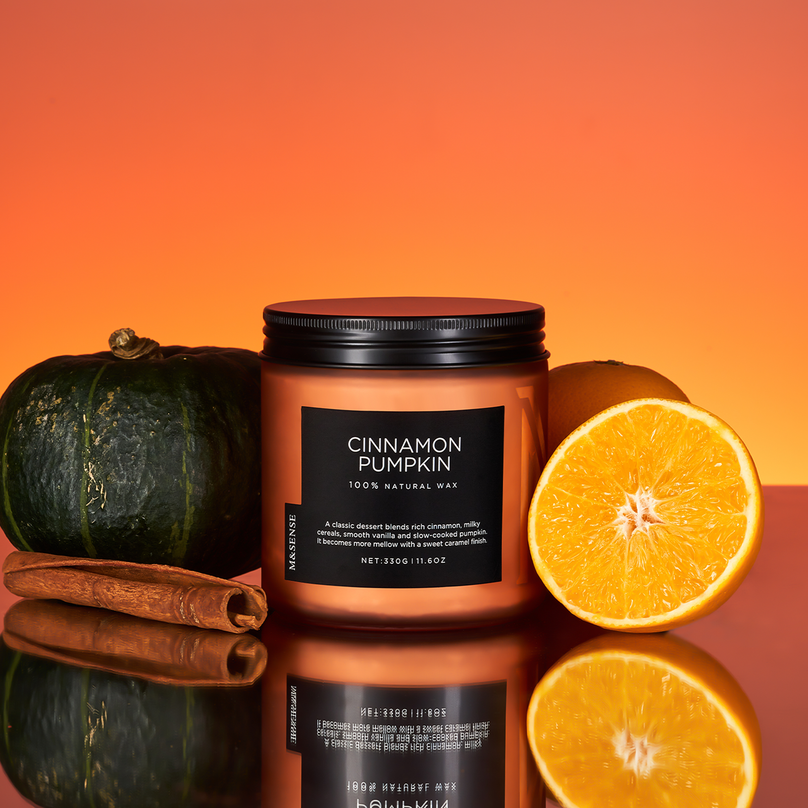 Candle labeled 'Cinnamon Pumpkin' with a pumpkin, orange, and cinnamon stick on an orange background
