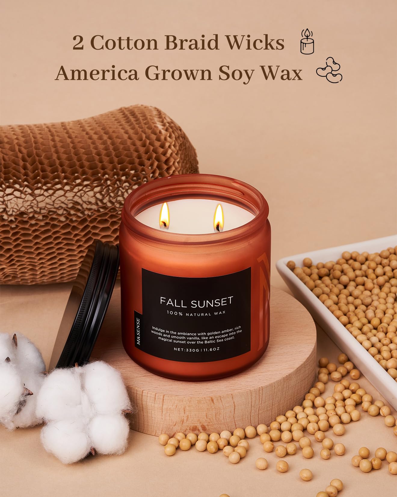 Candle with 'Fall Sunset' label on a wooden stand, surrounded by soybeans and cotton, with text about wicks and wax quality.