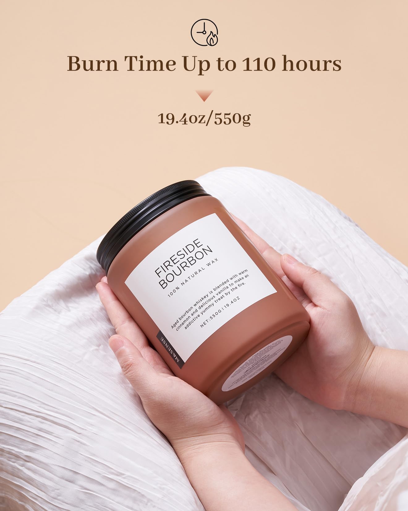 Candle labeled 'Fireside Bourbon' held by a hand with a beige background