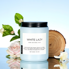 Candle labeled 'White Lazy' with floral and wooden background