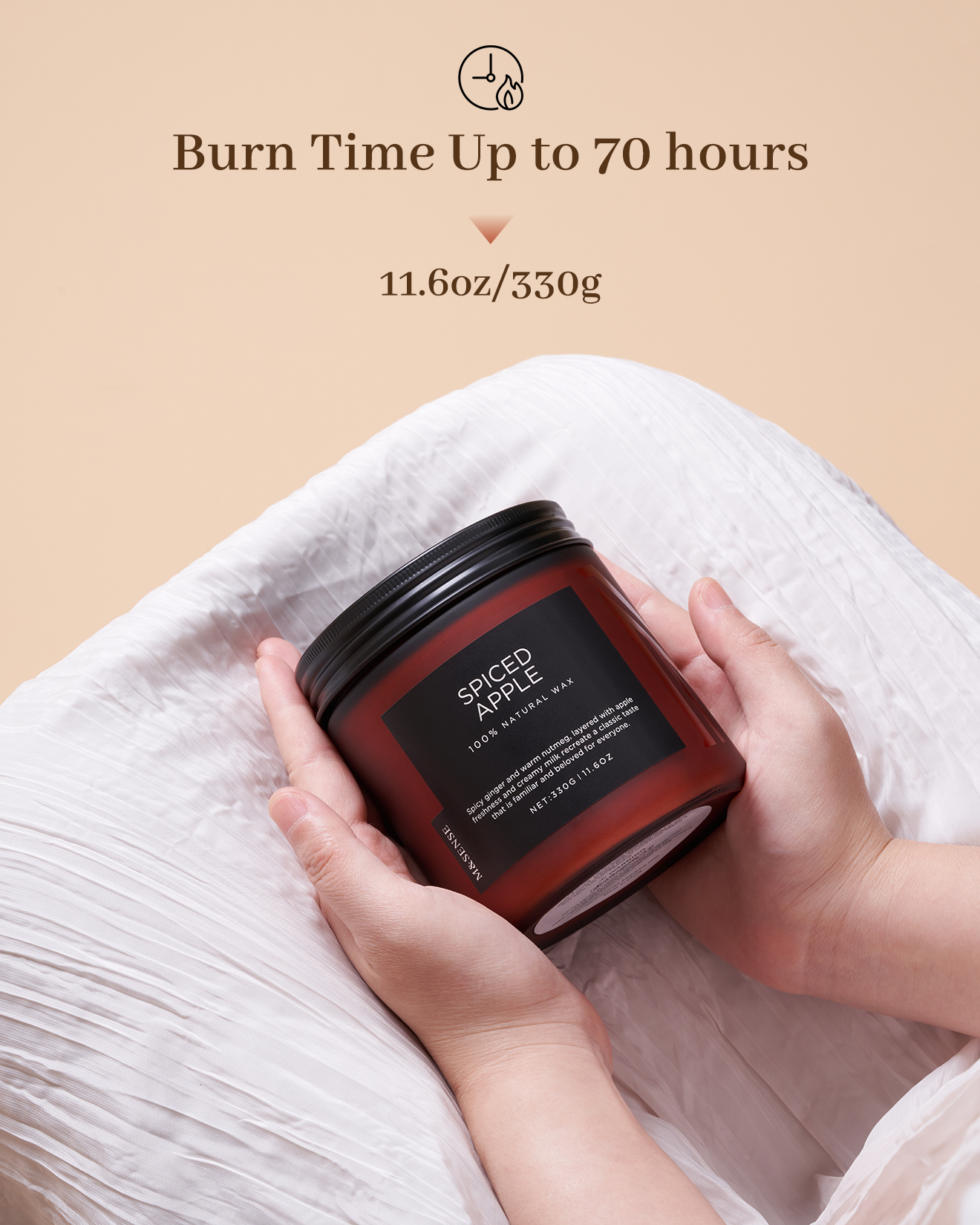 Candle jar labeled 'Spiced Apple' held by hands on a beige background with text about burn time.