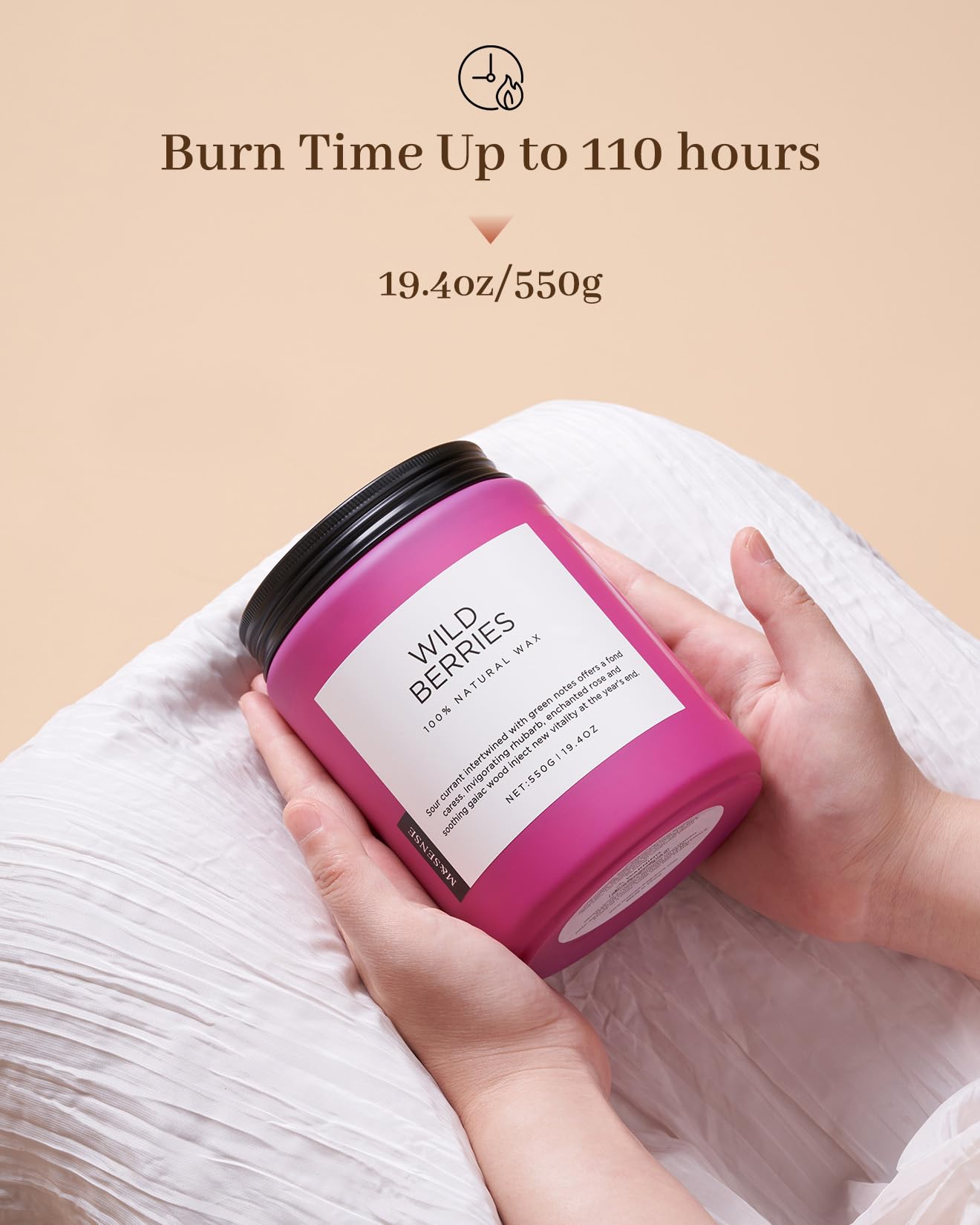 Pink candle labeled 'Wild Berries' held by a hand with beige background